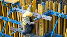 Construction worker using safety gear on scaffolding, demonstrating proper workplace safety practices for Level 2 training.